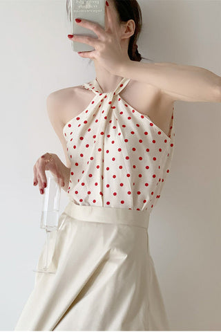 Elegante top corto con cuello halter y estampado de lunares 