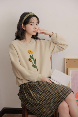 Sudadera con pompones y flores silvestres