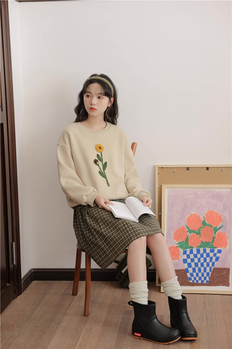 Sudadera con pompones y flores silvestres