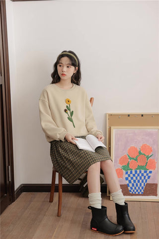 Sudadera con pompones y flores silvestres