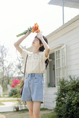 Blusa bordada con gerberas naranjas